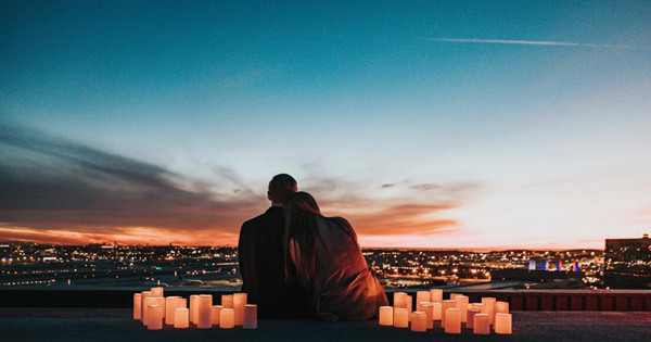 A beautiful landscape photo with mountains, clear sky and a flowing river, surrounded by lush green trees.